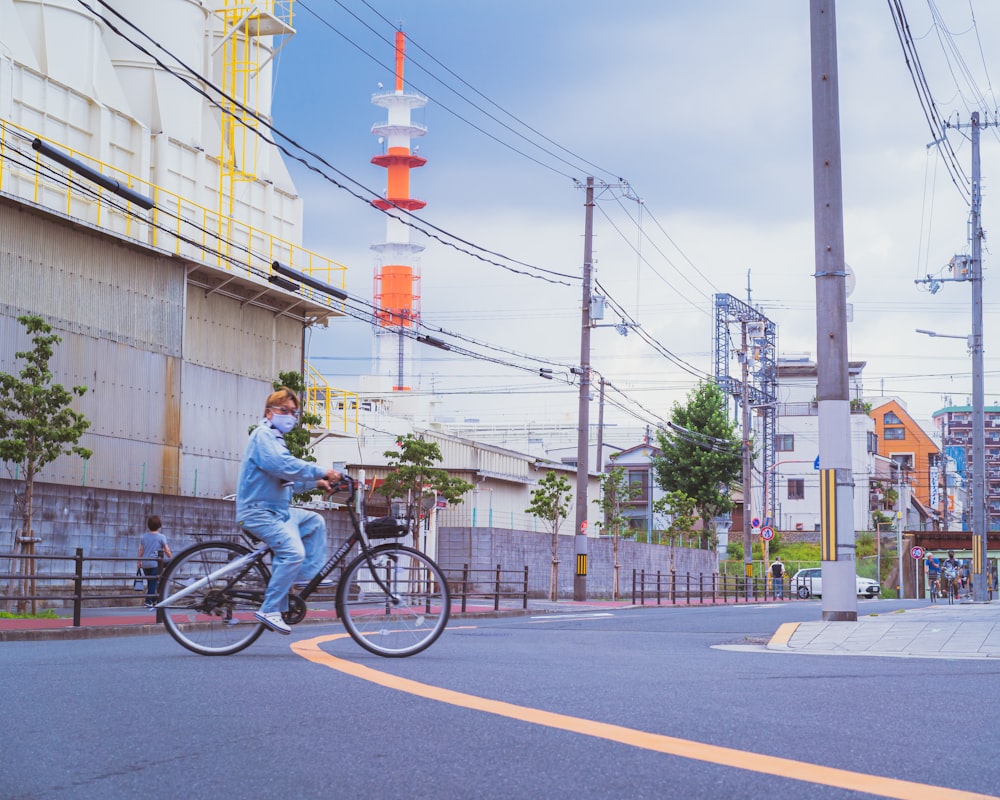 a man riding a bike down a street next to a tall building