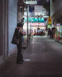 A person walking alone in a city at dusk, phone screen showing the Vigilia app.