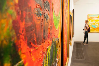 a woman is looking at paintings in a museum
