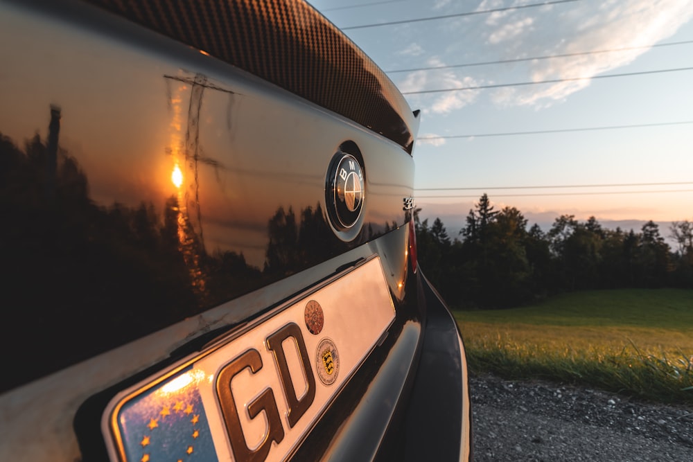 a car parked on a gravel road with a sunset in the background