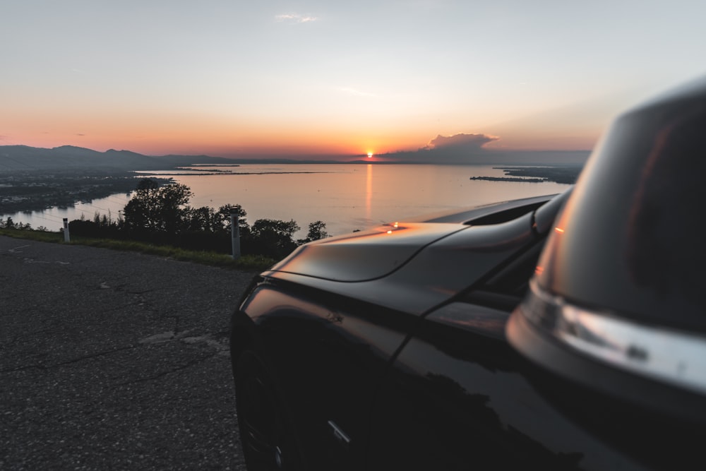 a car parked on the side of a road near a body of water