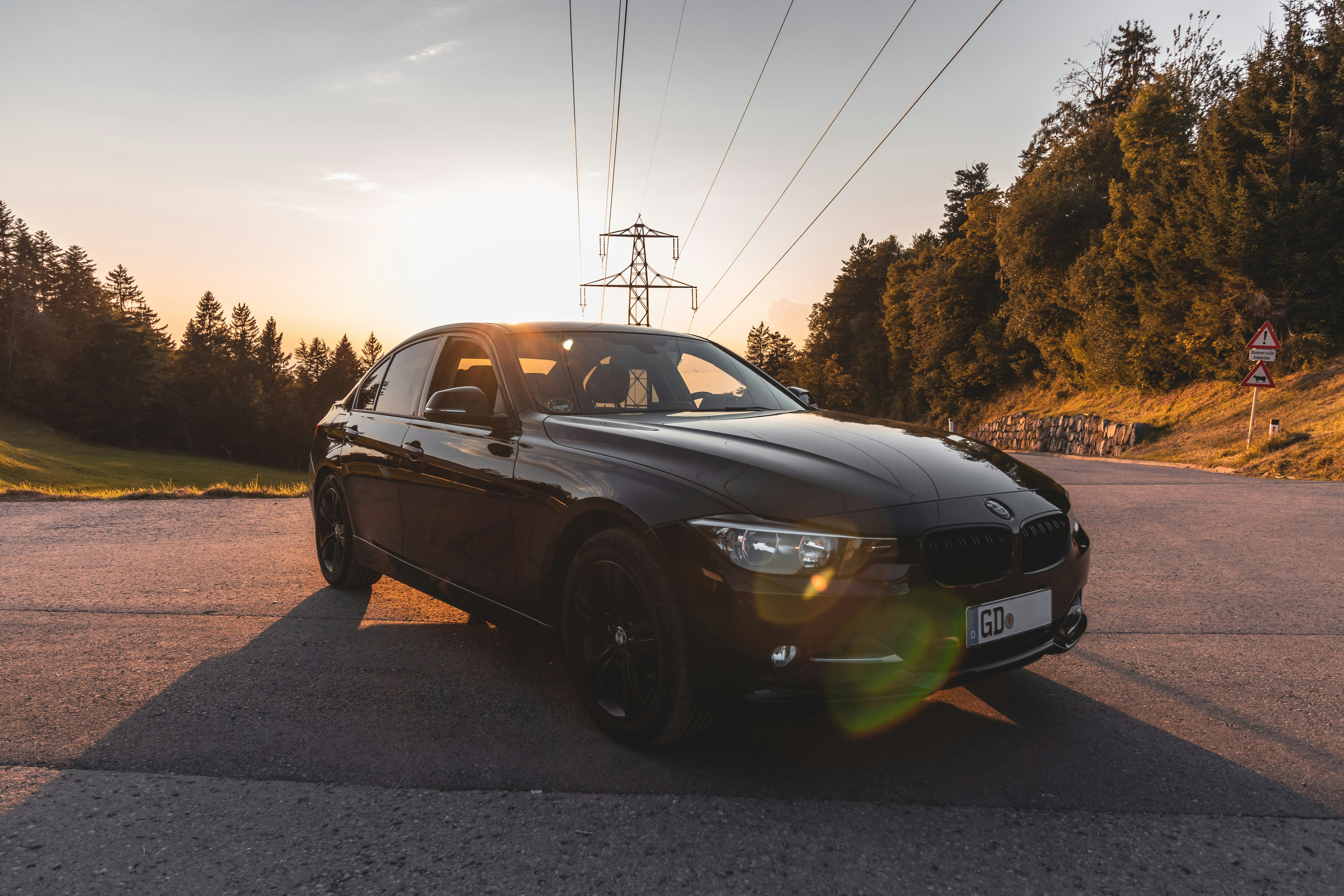 Sleek modern car on an empty road at golden hour, warm tones, open highway