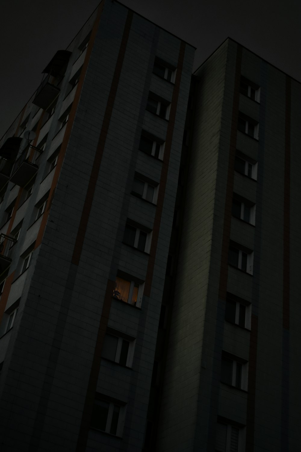 a tall building with two windows at night