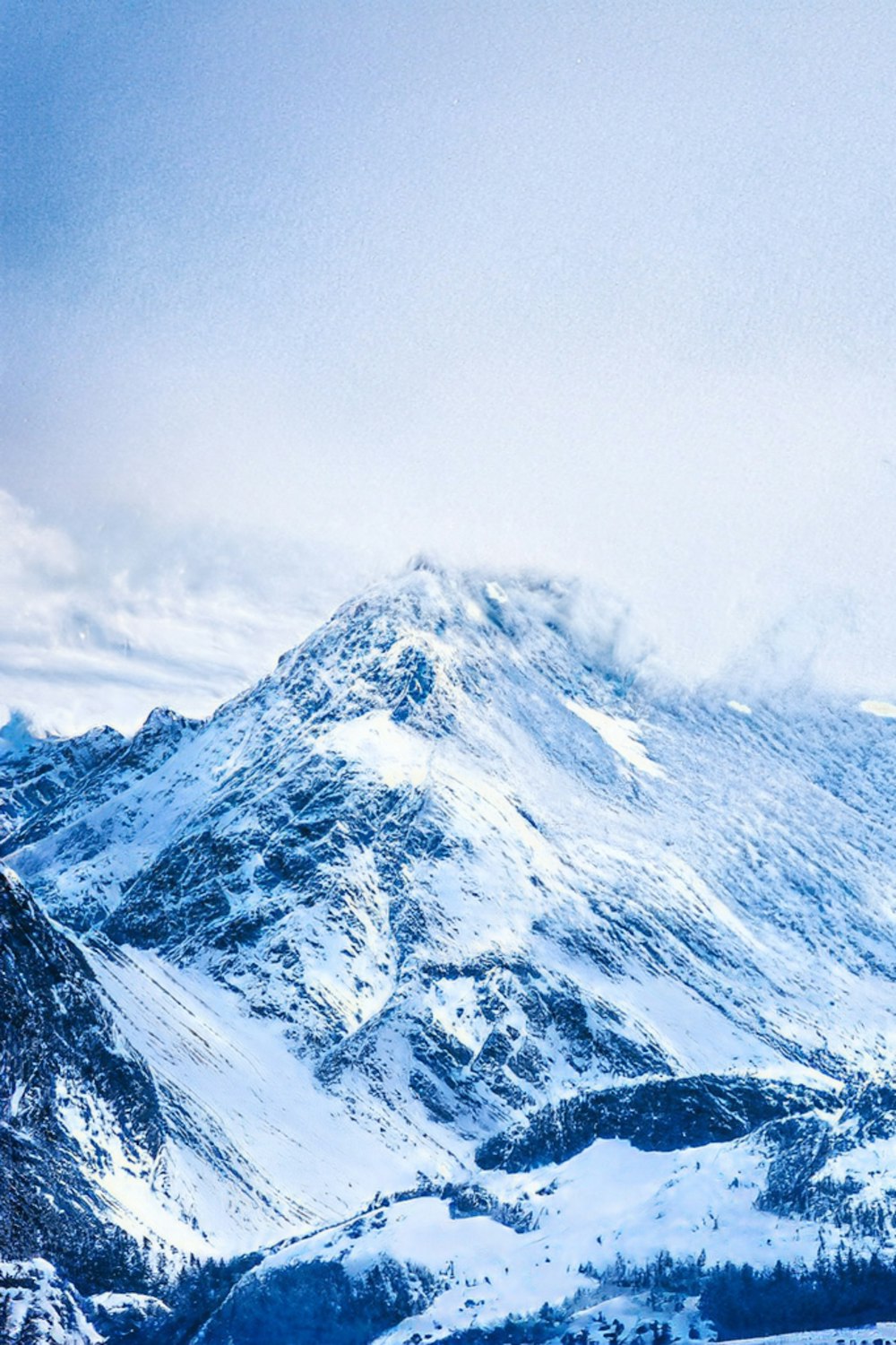 a snowboarder is standing on the top of a snowy mountain