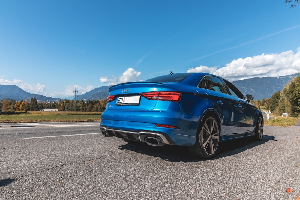 a blue car parked on the side of the road