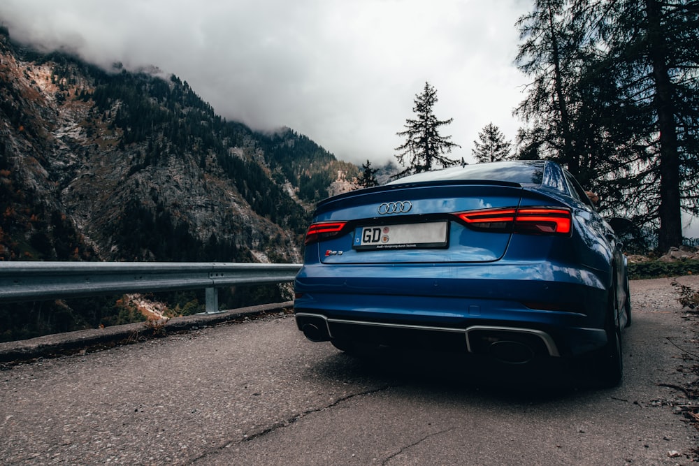 a blue car parked on the side of a road