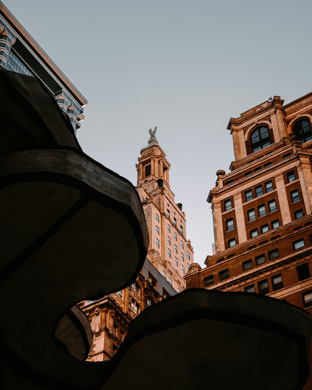 a clock tower towering over a city with tall buildings