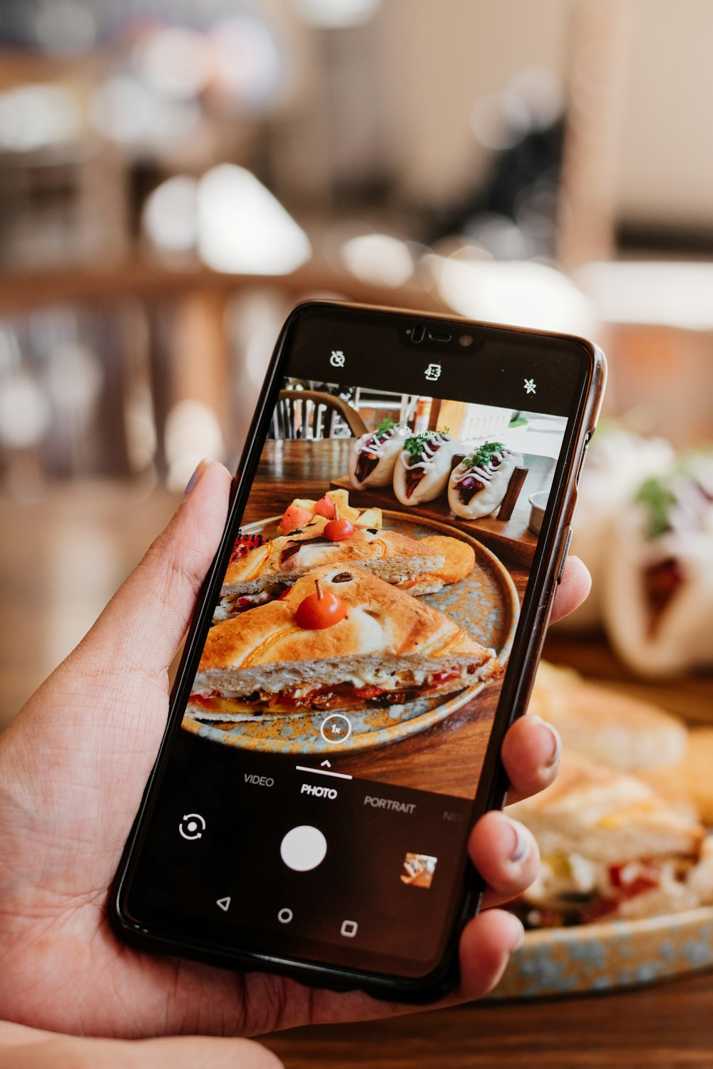 Eine Person, die ein Foto von Essen auf ihrem Handy macht