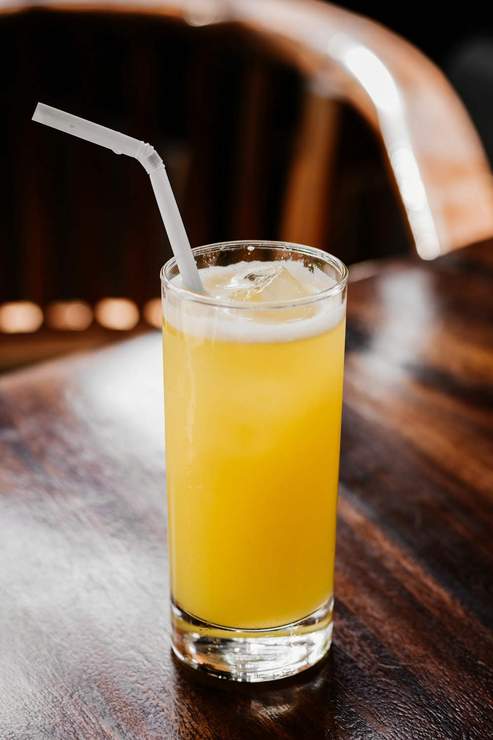 a glass of orange juice on a wooden table