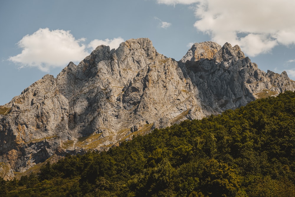 a very tall mountain with some clouds in the sky