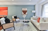 a living room filled with furniture and a painting on the wall