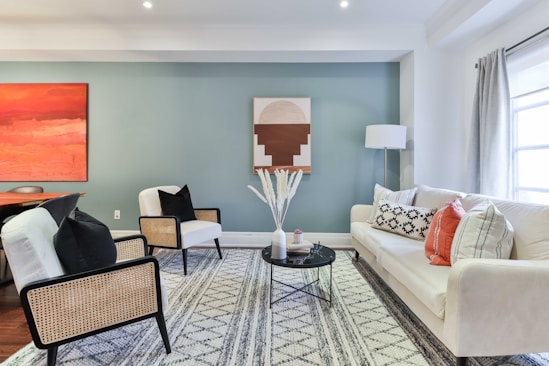 a living room filled with furniture and a painting on the wall