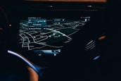 A car dashboard with a high-tech navigation system displayed clearly on a sleek touchscreen, showing detailed maps and directions in a low light environment. The interface has a modern and futuristic design with various navigation options visible.