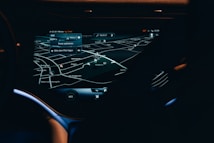 A car dashboard with a high-tech navigation system displayed clearly on a sleek touchscreen, showing detailed maps and directions in a low light environment. The interface has a modern and futuristic design with various navigation options visible.