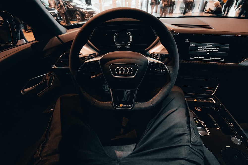 the inside of a car with a steering wheel and dashboard