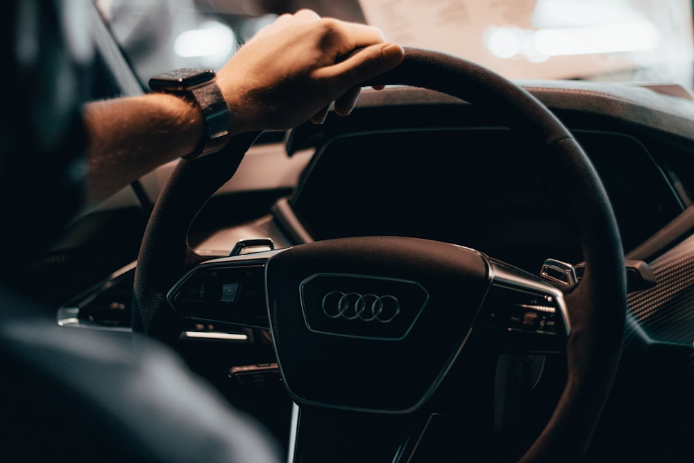 a person driving a car with a steering wheel