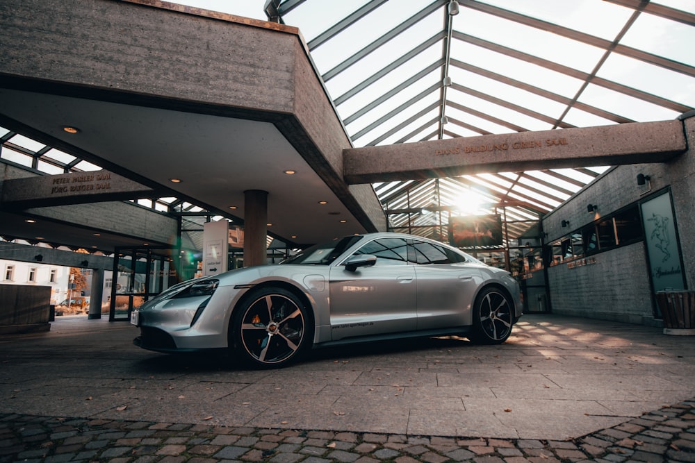 a silver sports car parked in front of a building