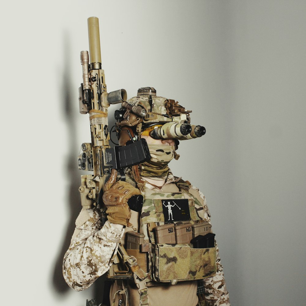 a man dressed in camouflage holding a rifle