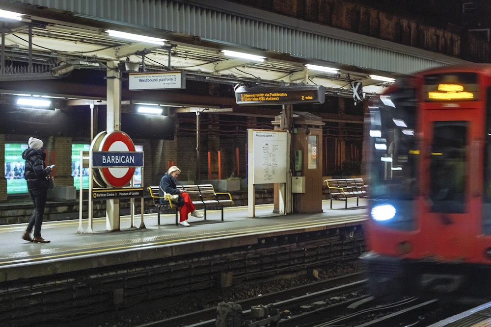 a red train pulling into a train station