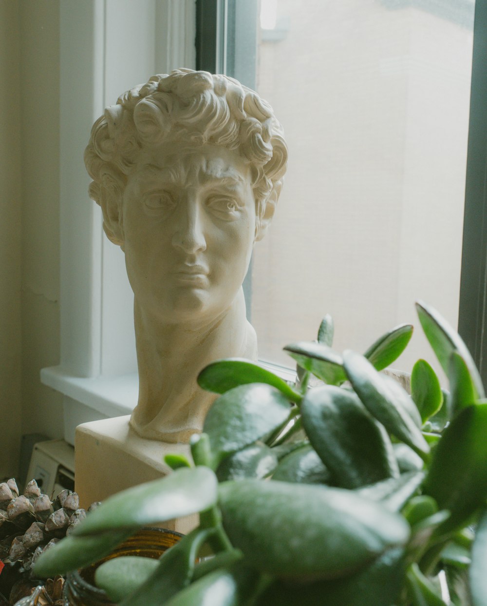 a statue of a man next to a potted plant