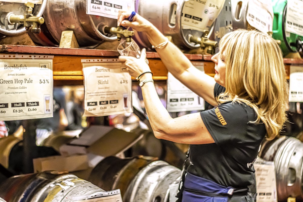 a woman working on a wine barrel in a wine shop
