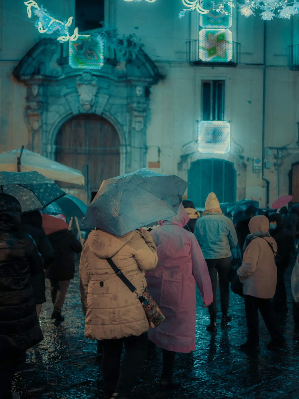 a group of people walking down a street holding umbrellas