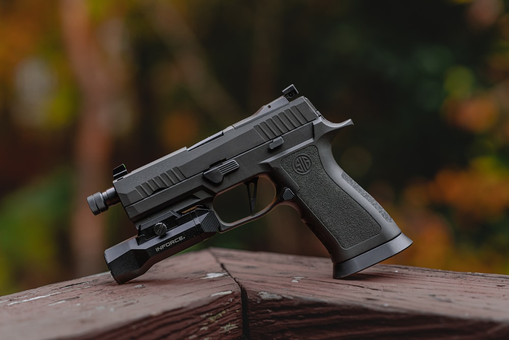 a close up of a gun on a wooden surface