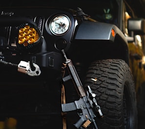 a black jeep with a gun on the front of it