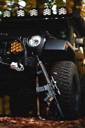 a black jeep with a gun on the front of it