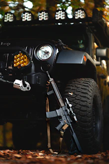 a black jeep with a gun on the front of it