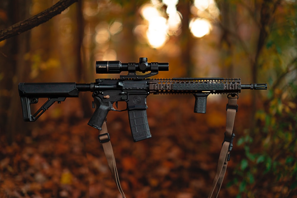 a rifle with a scope attached to it in the woods