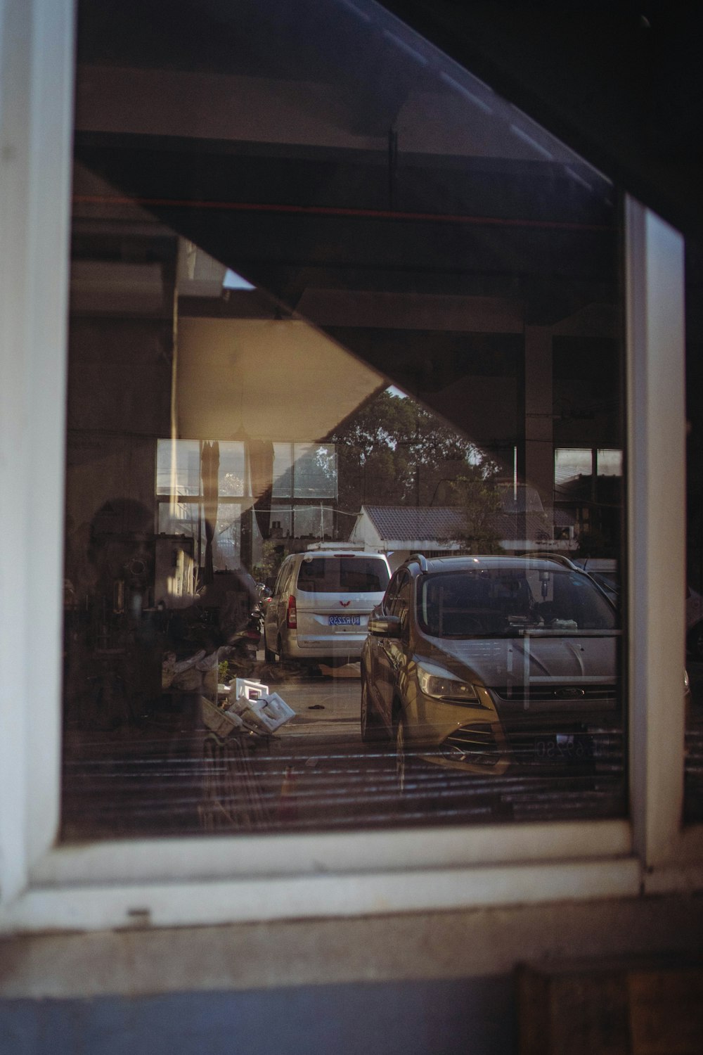 a reflection of cars in a window of a building
