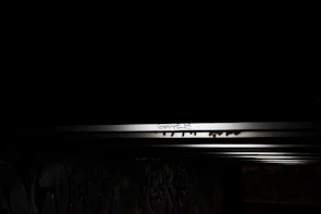 Workshop participants spray-painting bold street art under moody urban lighting.