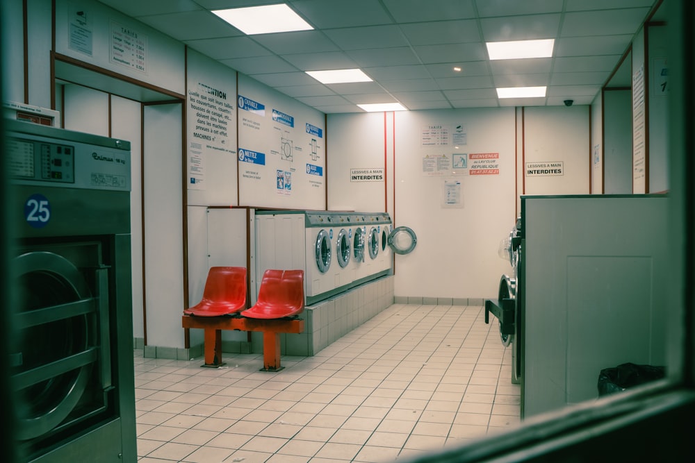 a row of red chairs sitting next to a dryer