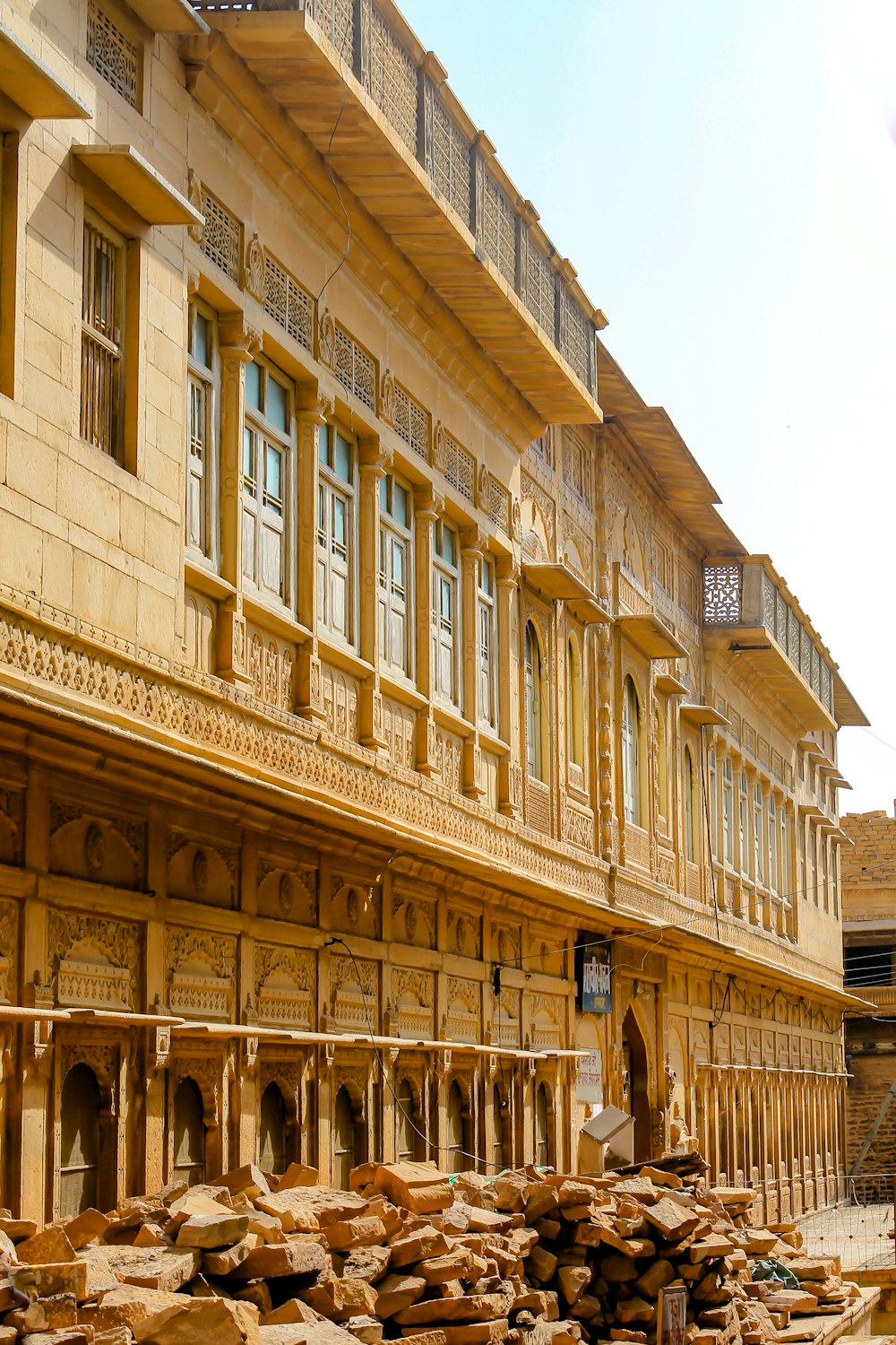 an old building with a pile of wood in front of it