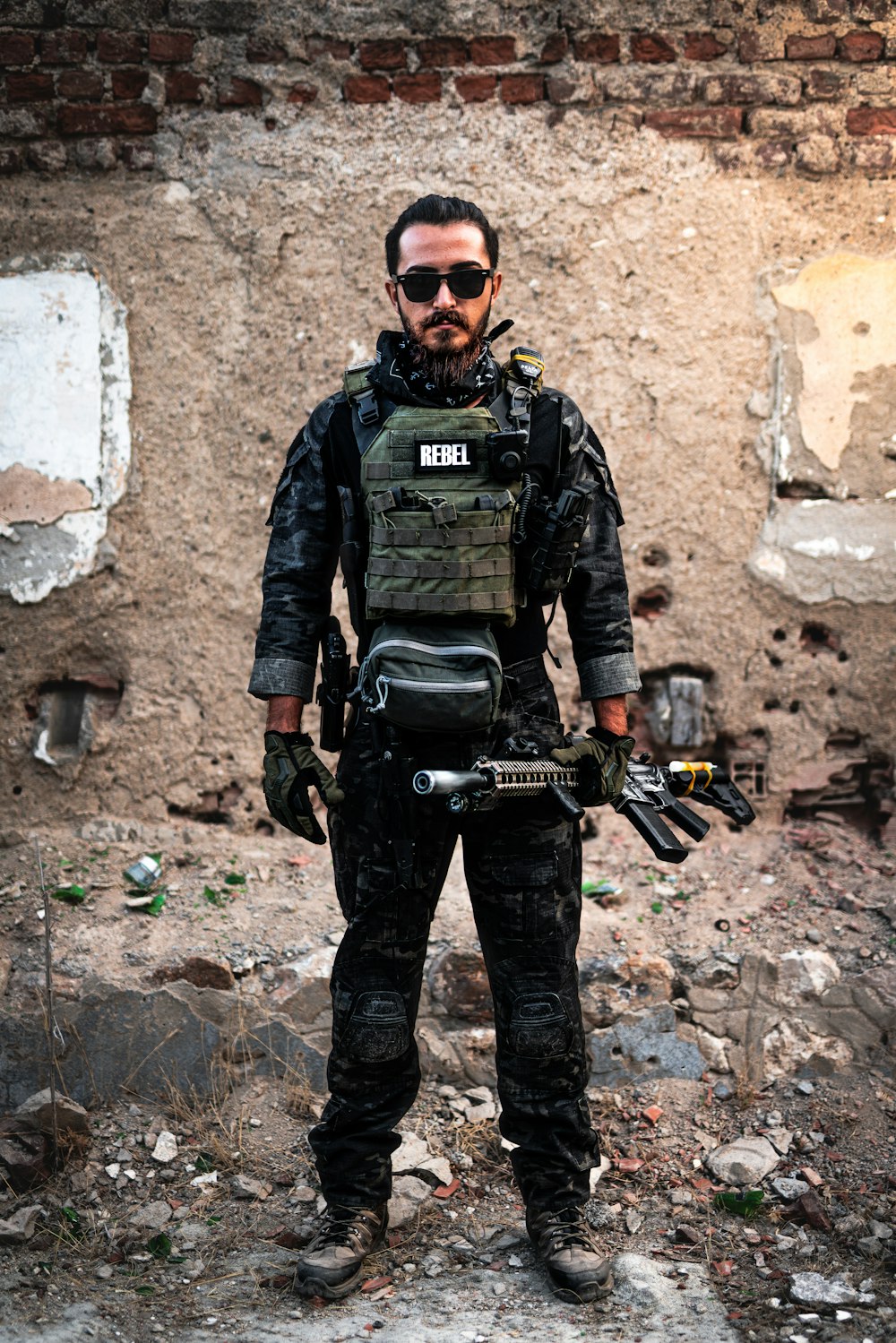 a man standing in front of a brick wall