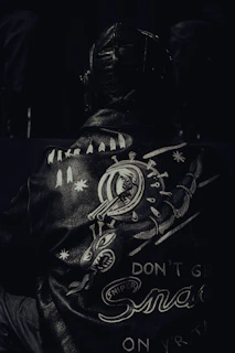 a black and white photo of a man wearing a leather jacket