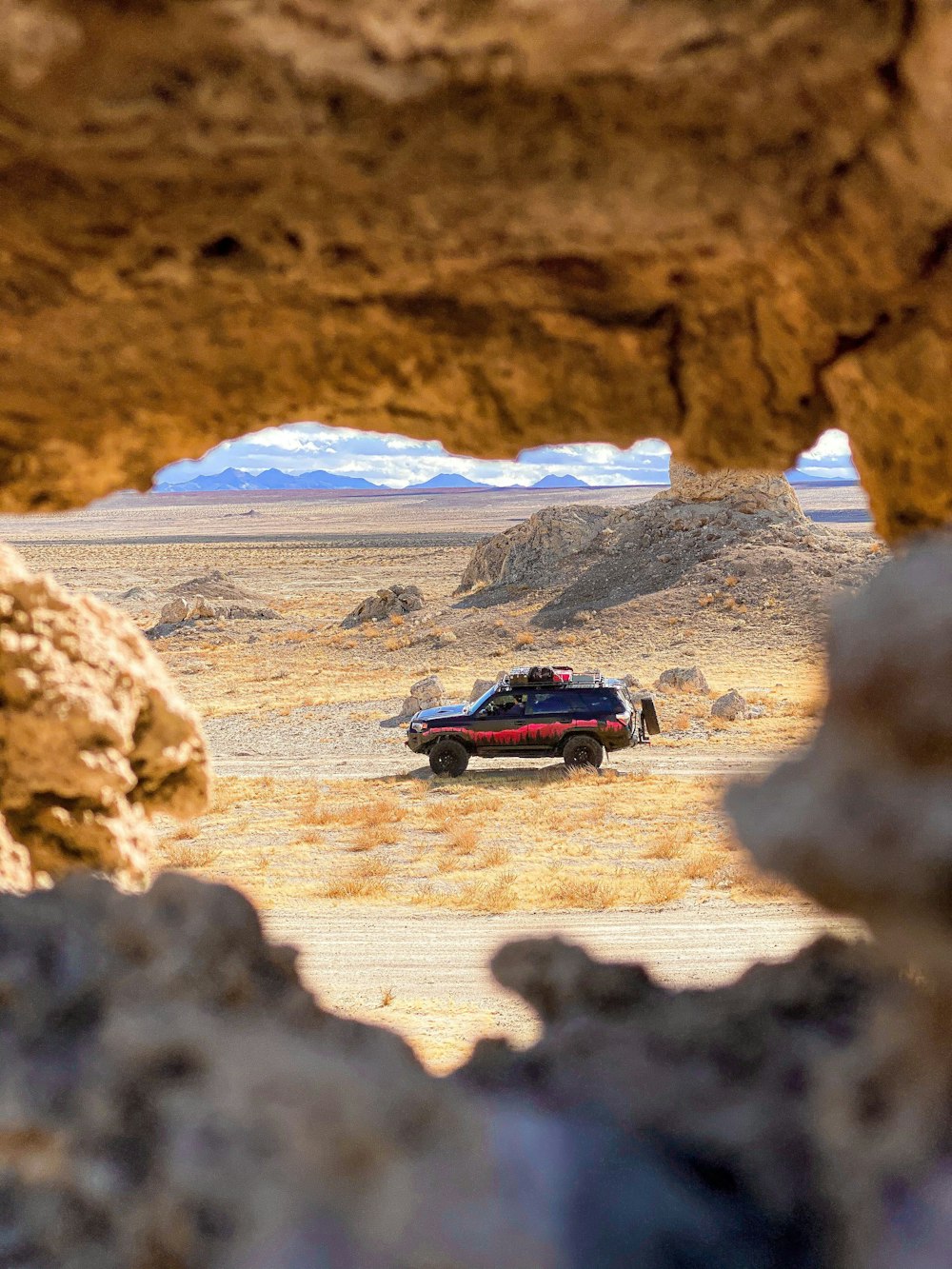 a car is parked in the middle of the desert