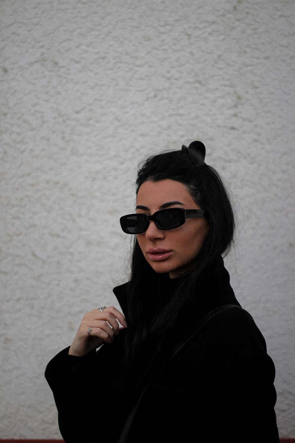 a woman wearing sunglasses and a black coat
