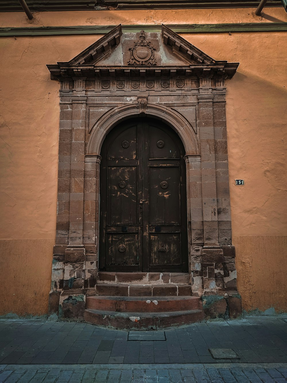 una puerta con un reloj en el costado de un edificio