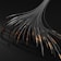 Numerous black cables or tubes with metallic and copper elements appear to be extending from a singular point, creating a fan-like spread. The cables have a textured spiral pattern, and the image has a dark, industrial aesthetic.