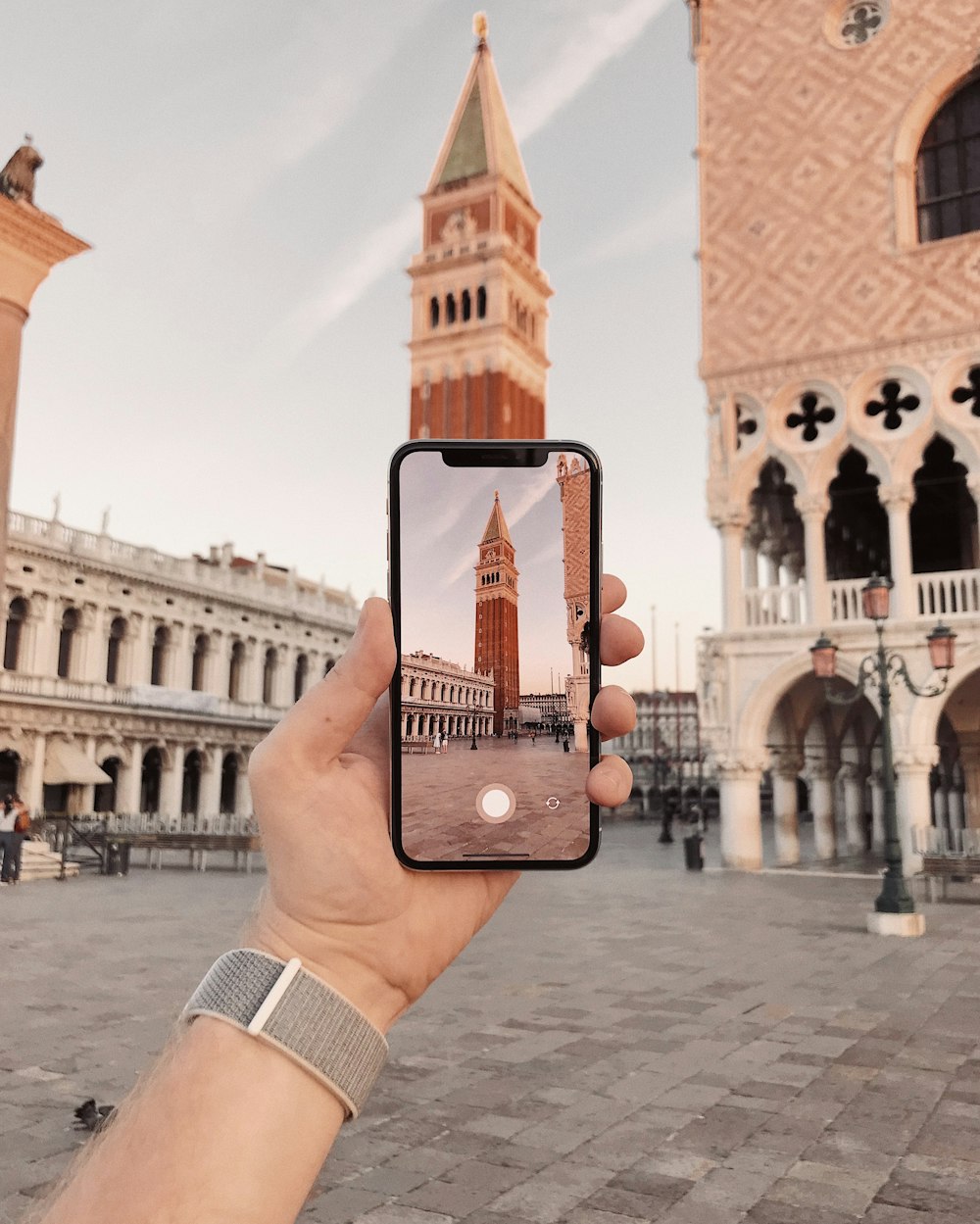 una persona che scatta una foto di una torre dell'orologio