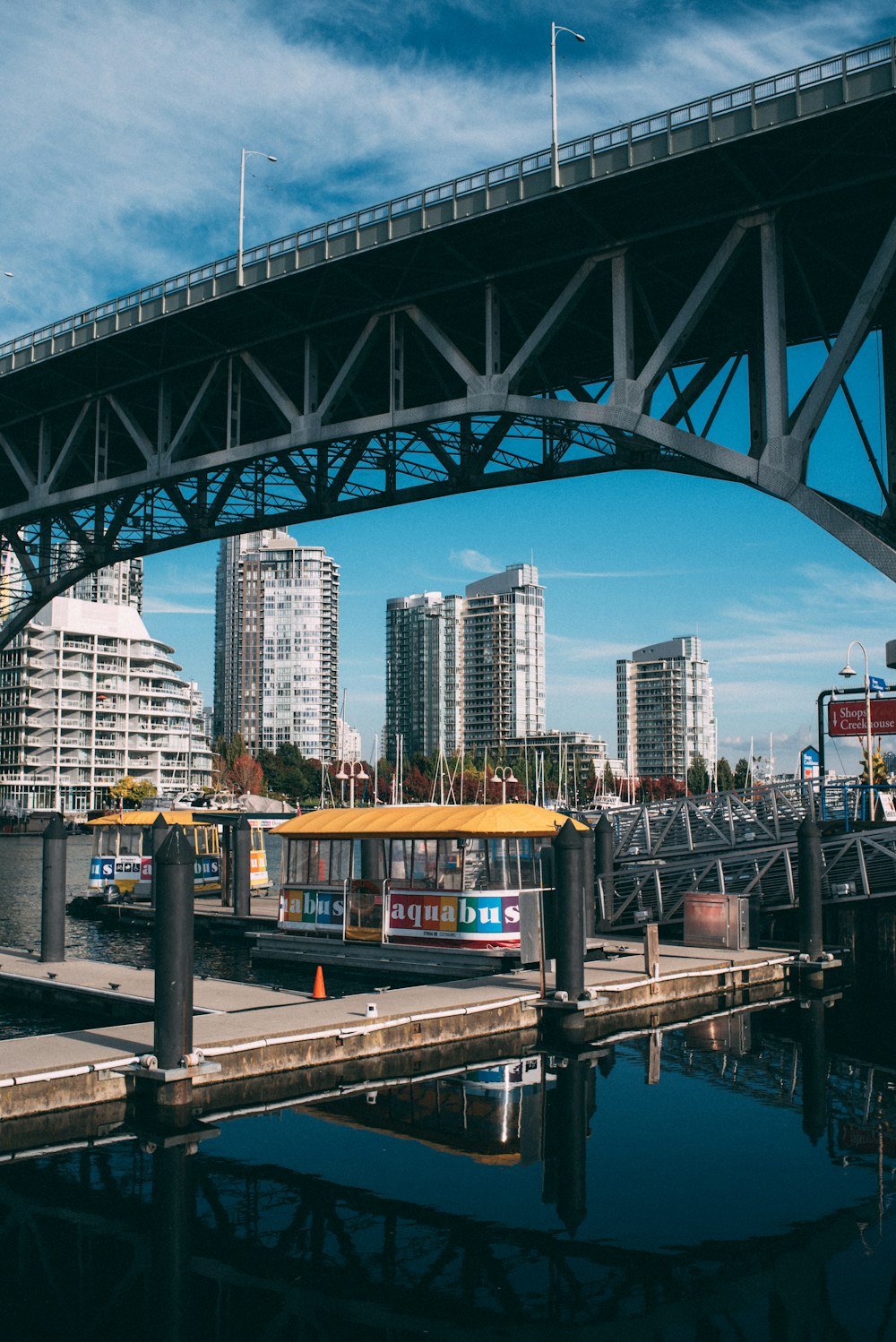 a bridge over a body of water with a city in the background