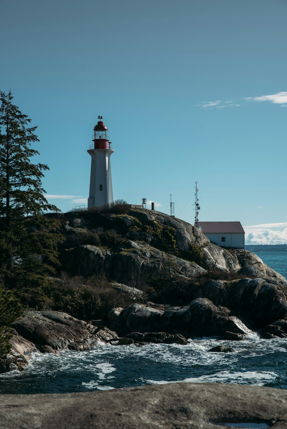 a lighthouse on top of a large rock near the ocean