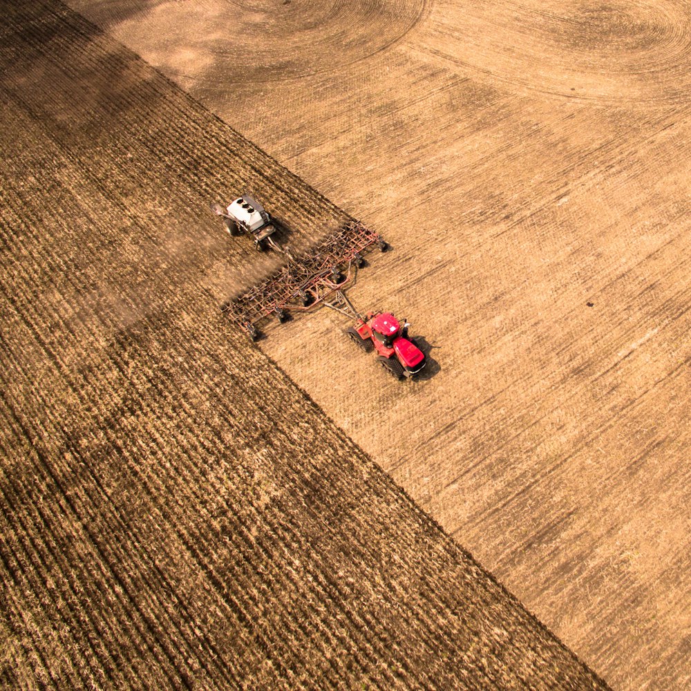 a red tractor is in a large field