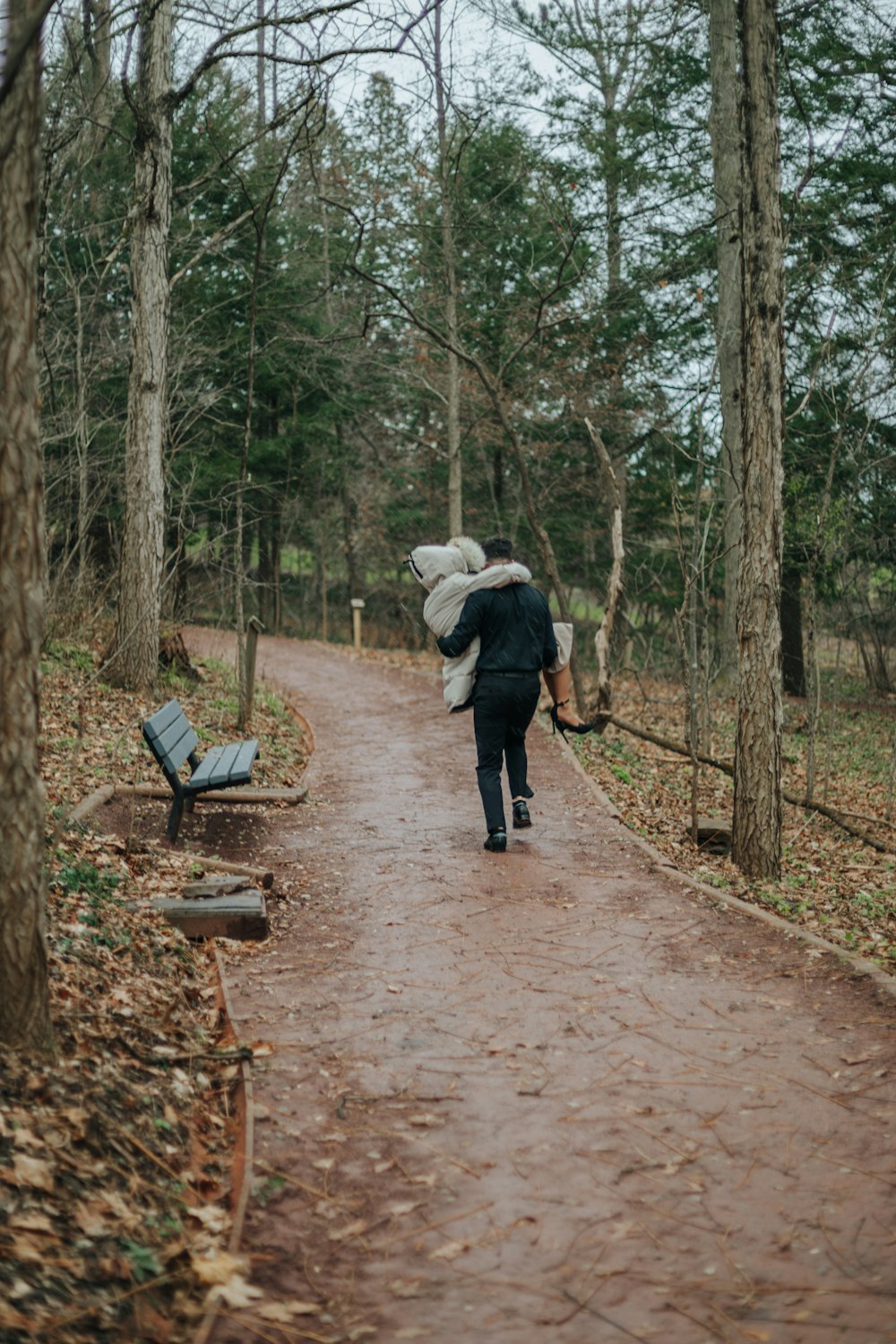 a person walking down a path carrying a bag