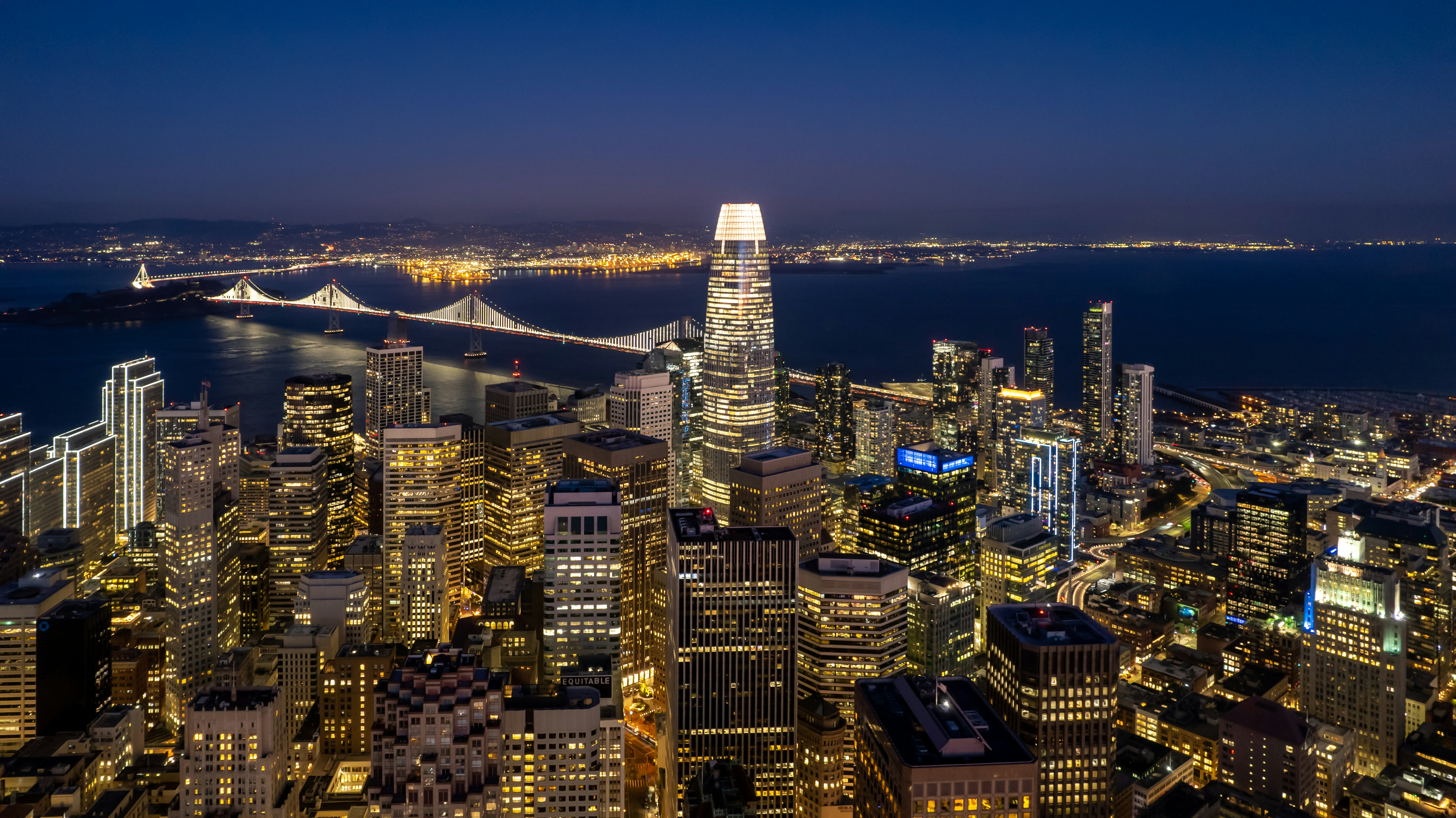 a view of a city at night with a bridge in the background, When the lights go on in the City.....