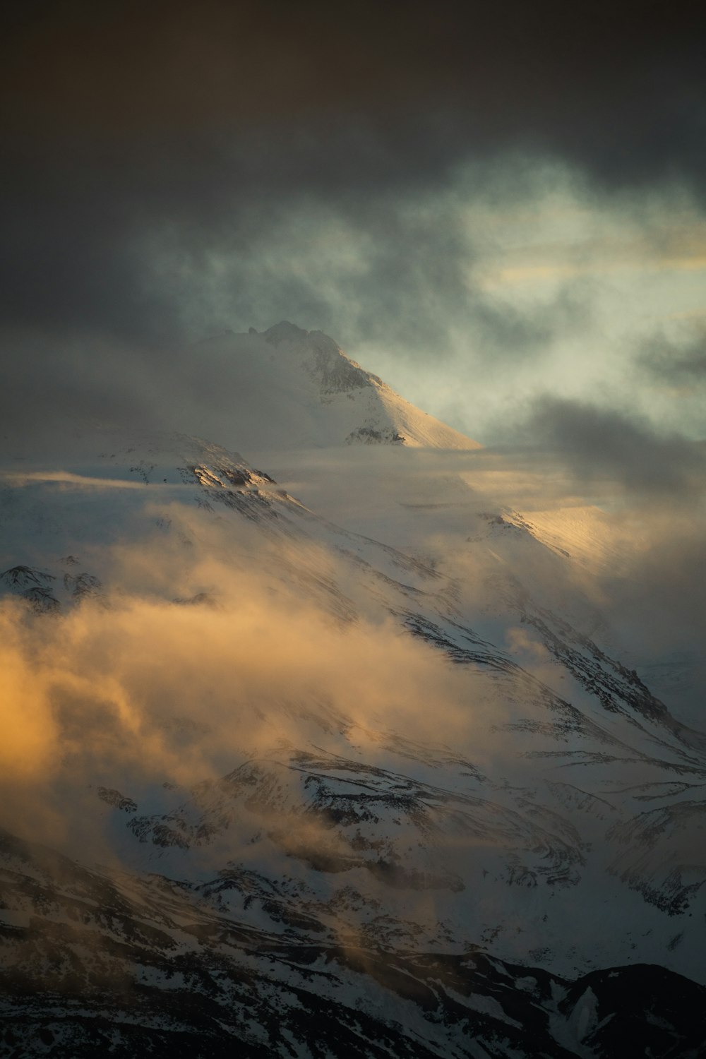 Une montagne couverte de neige sous un ciel nuageux