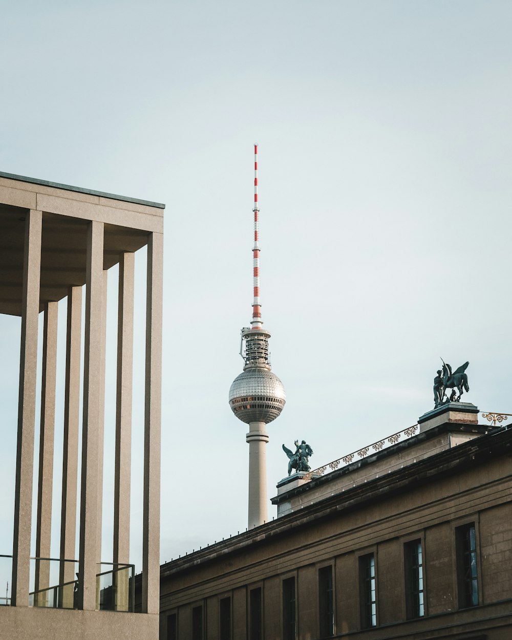 a tall building with a red and white antenna on top of it