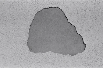 a black and white photo of a crack in a concrete wall